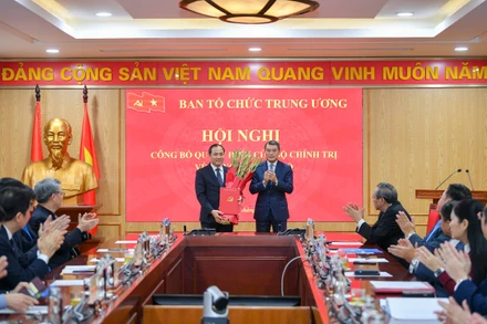 Đồng chí Lê Minh Hưng, Ủy viên Bộ Chính trị, Bí thư Trung ương Đảng, Trưởng Ban Tổ chức Trung ương trao quyết định, tặng hoa chúc mừng đồng chí Hoàng Trung Dũng (Ảnh: Thế Đại)