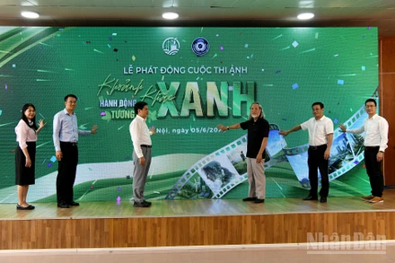 Các đại biểu thực hiện nghi thức phát động Cuộc thi ảnh “Khoảnh khắc xanh - Hành động xanh - Tương lai xanh”. Ảnh: Nguyễn Dương.