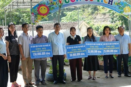 Ngành giáo dục Nghệ An trao tiền hỗ trợ cho các trường ở vùng lũ bị thiệt hại.