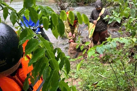 Lực lượng chức năng băng rừng, lội suối tổ chức tìm kiếm người dân bị mắc kẹt trong rừng sâu. 