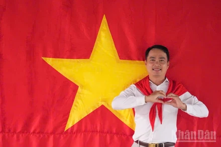 Tiến sĩ Võ Văn Sơn, giảng viên trẻ của Trường đại học Tiền Giang chụp ảnh cùng cờ Tổ quốc.