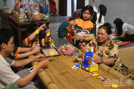 Nghệ nhân Nguyễn Thị Tuyến giới thiệu đồ chơi Tiến sĩ giấy với các bạn trẻ.