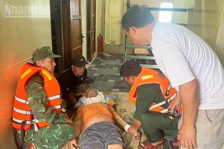 Cán bộ, chiến sĩ Đồn Biên phòng Cửa khẩu Cảng Vũng Rô khẩn trương sơ cứu thuyền viên bị chấn thương ngay tại khoang tàu.