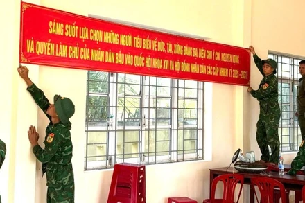 Cán bộ, chiến sĩ Đồn Biên phòng Xuân Hòa treo băng rôn tuyên truyền, hoàn thiện công tác trang trí tại khu vực bỏ phiếu trên địa bàn xã Xuân Cảnh.