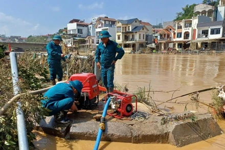 Lực lượng dân quân vận hành máy bơm, bơm nước vệ sinh đường phố, trường học tại phường Thục Phán, tỉnh Cao Bằng. (Ảnh MINH TUẤN)