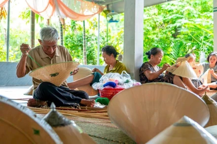 Nghệ nhân Ưu tú Đỗ Văn Lan đang thêu các họa tiết cho chiếc nón ngựa. (Ảnh: MỸ HÀ)