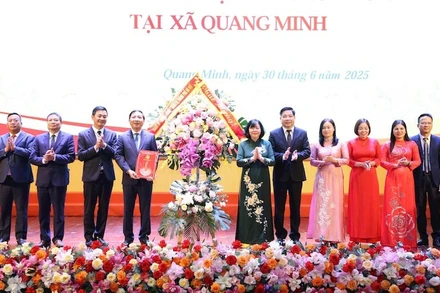 Đồng chí Bùi Thị Minh Hoài chúc mừng Ban Chấp hành Đảng bộ xã Quang Minh. (Ảnh: SƠN TÙNG).