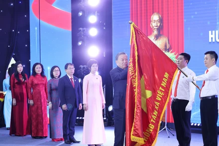 Tổng Bí thư Tô Lâm gắn Huân chương Hồ Chí Minh lên lá cờ truyền thống Thông tấn xã Việt Nam. Ảnh: Lâm Khánh - TTXVN