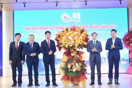 Thứ trưởng Y tế Trần Văn Thuấn tặng hoa chúc mừng Ban giám đốc Bệnh viện Đà Nẵng tổ chức thành công hội nghị. (Ảnh: ANH ĐÀO)