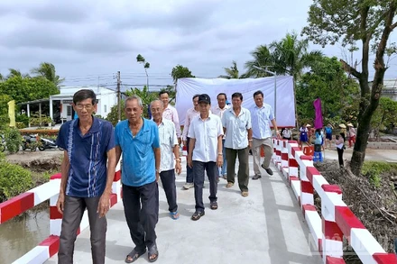 Người dân vùng quê ấp Lung Chim, xã Định Thành vui mừng đi qua cầu mới hoàn thành. 