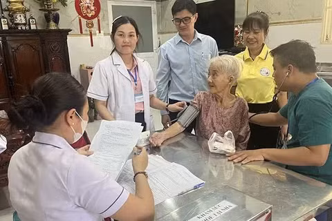 “Đội phản ứng nhanh” phường Minh Phụng (Thành phố Hồ Chí Minh) khám sức khỏe tại nhà cho bà Lê Thị Đời - 81 tuổi, đối tượng yếu thế. (Ảnh: MINH ANH)