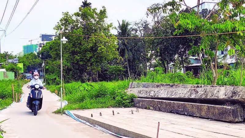 Cầu Trần Bạch Đằng ngừng thi công, người dân phải tự làm đường dân sinh đi lại giữa hai khu tái định cư.