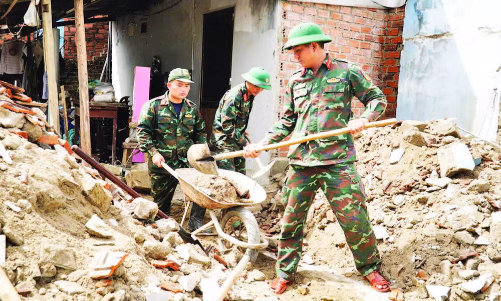 Cán bộ, chiến sĩ Trường Quân sự (Quân đoàn 34, tỉnh Gia Lai) hỗ trợ sửa chữa, xây dựng nhà cửa cho người dân sau bão lũ tại phường Ngô Mây.