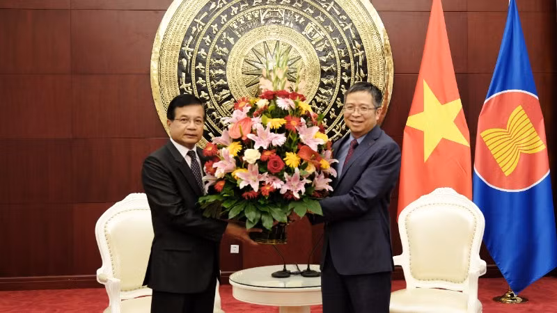 Đại sứ Lào Somphone Sichaleune tặng hoa chúc mừng Đại sứ Phạm Thanh Bình. (Ảnh: Đại sứ quán Việt Nam cung cấp)