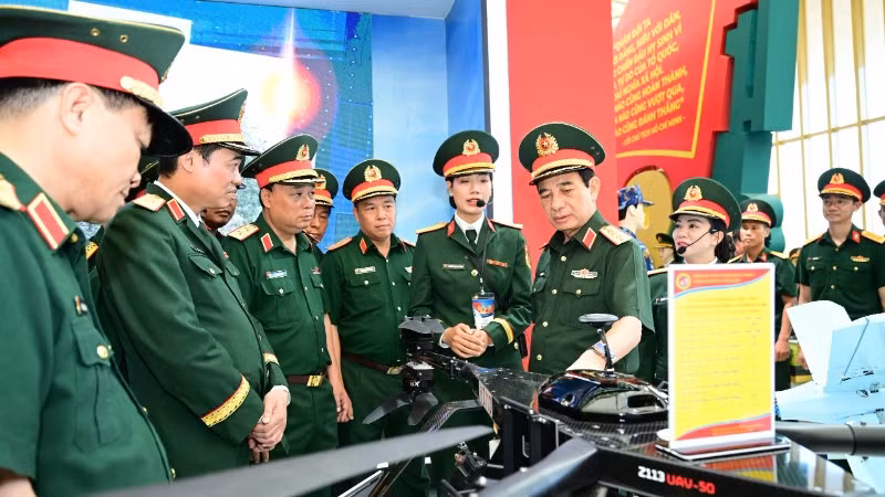 Đại tướng Phan Văn Giang kiểm tra khu trưng bày trong nhà của Bộ Quốc phòng tại Triển lãm thành tựu đất nước. (Ảnh VIỆT TRUNG)