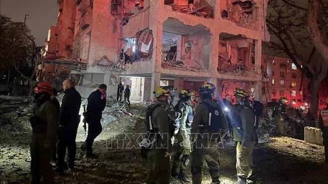 Các lực lượng ứng cứu khẩn cấp tại hiện trường vụ tấn công bằng tên lửa đạn đạo của Iran ở thành phố Arad, miền Nam Israel tối 21/3/2026. (Ảnh: TTXVN)