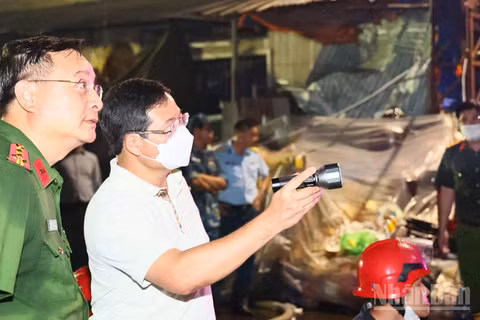 Đại tá Trần Anh Sơn, Phó Giám đốc Công an thành phố Đồng Nai (người cầm đèn pin) chỉ đạo công tác chữa cháy tại hiện trường tối 5/8. 
