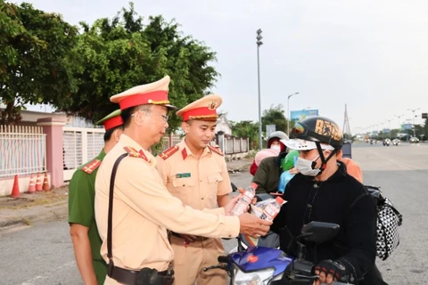 Công an Cần Thơ phát nước cho người dân trên đường về nhà đón Tết.