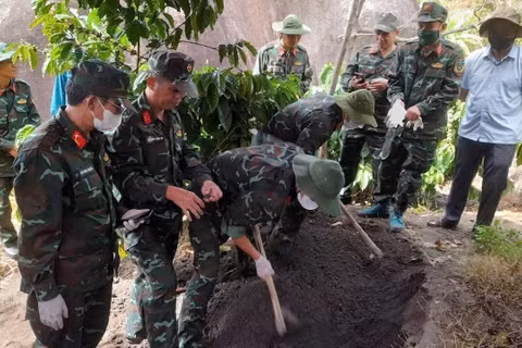 Các lực lượng chức năng tiến hành khai quật tìm hài cốt liệt sĩ. (Ảnh: Quốc Khánh)