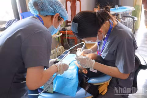Các y bác sĩ Bệnh viện Răng-Hàm-Mặt thành phố Đà Nẵng khám răng cho học sinh trên địa bàn xã Phước Năng.