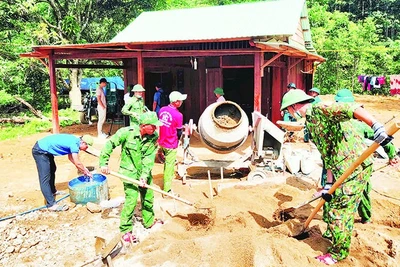 Cán bộ, chiến sĩ Đồn Biên phòng Đắc Pring giúp người dân vùng biên xây dựng nhà mới.