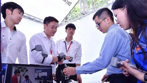 Các nhà đầu tư và thanh niên tham quan gian hàng trình diễn sản phẩm khởi nghiệp đổi mới sáng tạo về khoa học-công nghệ tại một triển lãm do Thành Đoàn Hà Nội tổ chức.