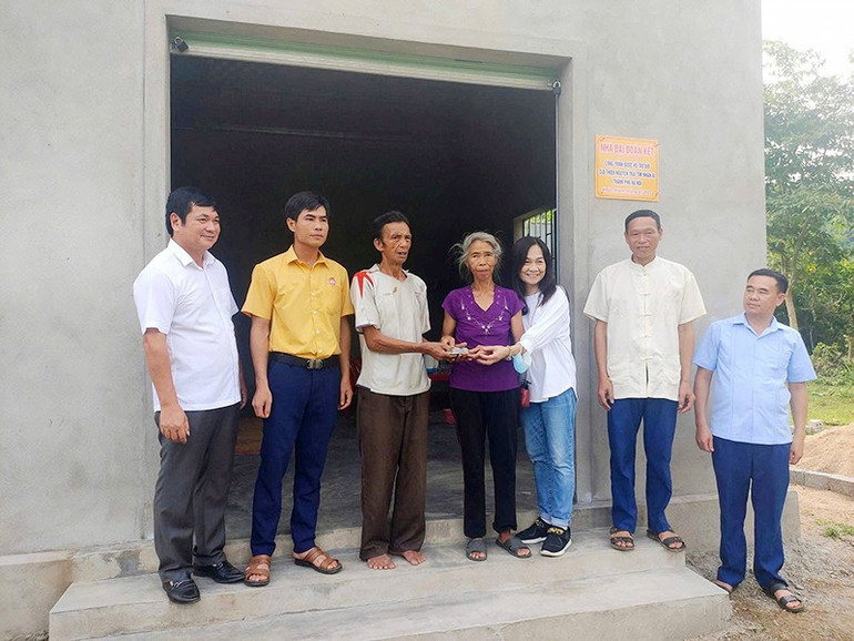 Chị Hồ Phương Thảo (thứ 3 từ phải sang) đại diện nhóm “Trái tim nhân ái” trao kinh phí xây nhà Đại đoàn kết cho người dân nghèo. nha-tinh-thuong-chi-ho-phuong-thao.jpg