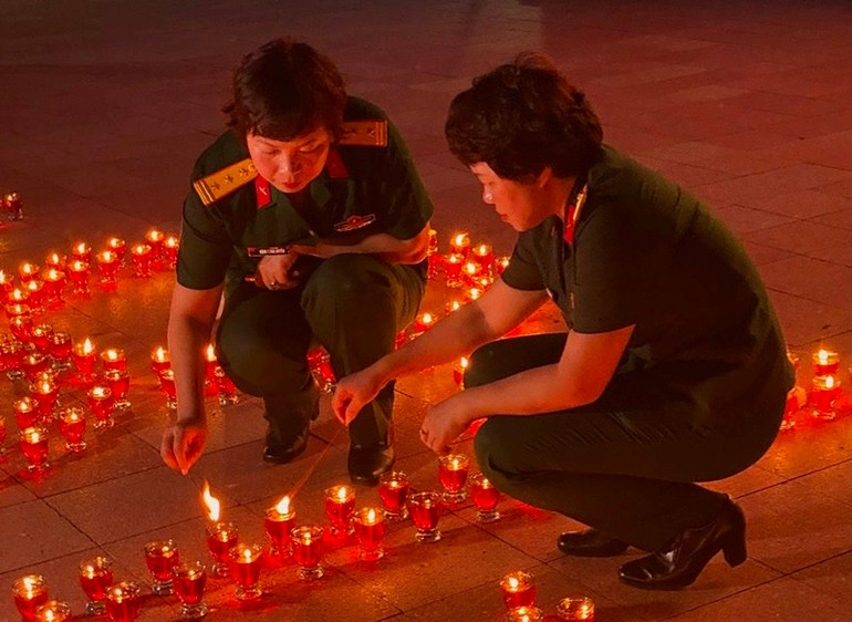 Đạo diễn Đặng Thái Huyền (trái) và Giám đốc sản xuất Kiều Thanh Thúy thắp nến tưởng niệm trước buổi chiếu. . Ảnh HUYỀN NGA 22.jpg