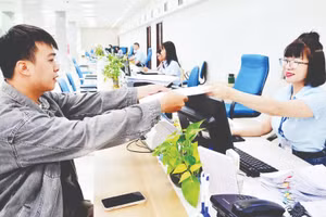 Cán bộ Trung tâm Phục vụ hành chính công tỉnh Quảng Ninh tiếp nhận, xử lý hồ sơ của công dân. (Ảnh THANH HOA)