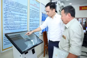 Hướng dẫn người dân thực hiện thủ tục hành chính tại Điểm phục vụ hành chính công xã Phúc Thịnh, thành phố Hà Nội. (Ảnh: NHẬT NAM)