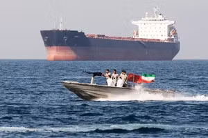 Lực lượng an ninh Iran tuần tra cạnh một tàu hàng ở Eo biển Hormuz. (Ảnh: GETTYIMAGES)