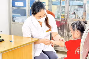 Cán bộ y tế kiểm tra, theo dõi trẻ mắc bệnh tay chân miệng trên địa bàn thành phố Hà Nội.