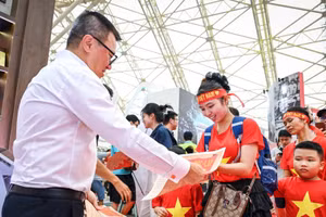 Tổng Biên tập Báo Nhân Dân Lê Quốc Minh phát phụ san đặc biệt của Báo Nhân Dân tới bạn đọc trẻ tại Triển lãm “80 năm Hành trình Độc lập - Tự do- Hạnh phúc”. (Ảnh: THÀNH ĐẠT)