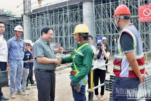 Thủ tướng Phạm Minh Chính ân cần hỏi thăm một công nhân xây dựng Nhà ga hành khách T2 thuộc Dự án đầu tư mở rộng Cảng hàng không quốc tế Phú Quốc. (Ảnh: THANH GIANG)
