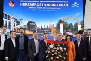 Đại sứ Nguyễn Đắc Thành và Phu nhân tặng hoa chúc mừng ông Nguyễn Văn Hiền, Tổng giám đốc Trung tâm Thương mại Đồng Xuân Berlin. (Ảnh: TTXVVN)