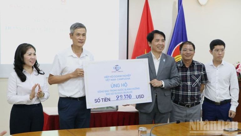 Đại sứ Nguyễn Minh Vũ (thứ hai từ trái sang) tiếp nhận tượng trưng số tiền ủng hộ của Hiệp hội Doanh nghiệp Việt Nam-Campuchia (VCBA). (Ảnh: HUY VŨ) ndo_br_img-5458.jpg