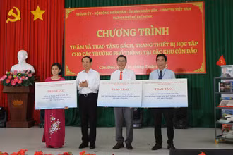 Đồng chí Nguyễn Văn Nên, Ủy viên Bộ Chính trị, Bí thư Thành ủy Thành phố Hồ Chí Minh trao bảng tượng trưng tặng sách và thiết bị học tập cho 3 trường tại Côn Đảo (Ảnh Ban tổ chức).