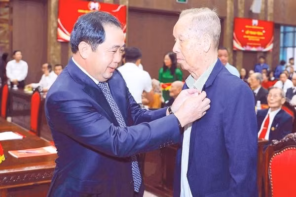 Bí thư Thành ủy Trần Đức Thắng gắn Huy hiệu Đảng tặng đảng viên lão thành (Ảnh THÁI QUANG)