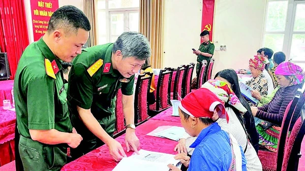 Cán bộ Đoàn Kinh tế-Quốc phòng 345 trao đổi, hướng dẫn người dân kỹ thuật chăn nuôi. (Ảnh QUANG PHẤN)