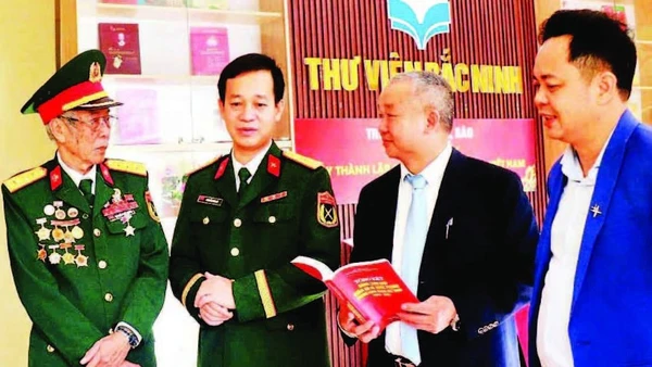 Giám đốc Thư viện Bắc Ninh số 1 Nguyễn Đắc Hồng (thứ hai, từ phải sang) trao đổi với độc giả tại một cuộc trưng bày sách.