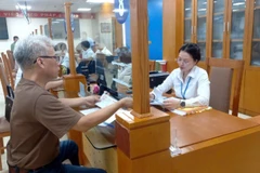 Người dân đến làm thủ tục hành chính tại phường Hoàn Kiếm trong sáng 1/7. (Ảnh: GIANG NAM)