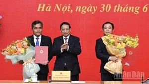 Thủ tướng Chính phủ Phạm Minh Chính trao Quyết định bổ nhiệm và tặng hoa chúc mừng hai đồng chí Trần Đức Thắng và Hồ Văn Niên. (Ảnh: TRẦN HẢI)