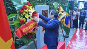 Thủ tướng Chính phủ Phạm Minh Chính chỉnh hoa chuẩn bị thực hiện nghi thức dâng hoa tưởng niệm Chủ tịch Hồ Chí Minh tại Rio de Janeiro (Ảnh: Thanh Giang).