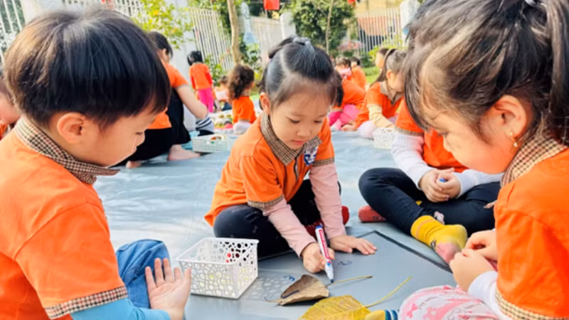 Các bạn nhỏ trong giờ hoạt động tạo hình con vật từ lá cây tại Trường mầm non Tuổi thơ (quận Hoàng Mai). 