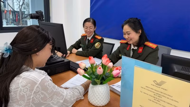 Cán bộ Công an thành phố Hà Nội hướng dẫn người dân kê khai làm thủ tục cấp hộ chiếu.