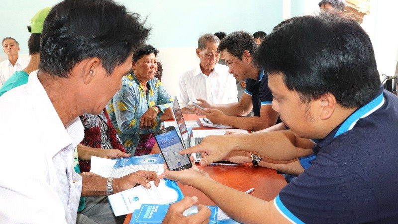 Nhân viên Xí nghiệp cấp nước Cần Giờ hướng dẫn và cài app SAWACO Chăm sóc khách hàng cho các hộ dân ở doi Mỹ Khánh.
