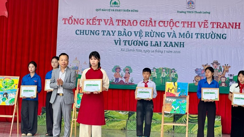 Ông Trần Xuân Tâm, Phó Giám giám đốc Quỹ Bảo vệ và Phát triển rừng tỉnh Điện Biên, trao giải Nhất cuộc thi cho em Mai Thùy Chi, lớp 8C1 Trường Trung học cơ sở Thanh Luông.