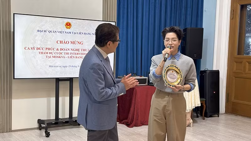 Đại sứ Đặng Minh Khôi trao kỷ niệm chương cho ca sĩ Đức Phúc.