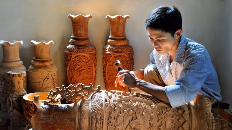 Người thợ chạm khắc gỗ tại làng nghề truyền thống Vân Hà (Hà Nội).