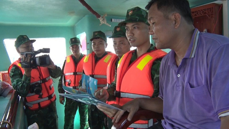 Thiếu tá Cường cùng đồng đội thực hiện công tác tuyên truyền an ninh biển đảo cho ngư dân. anh3-8861.jpg